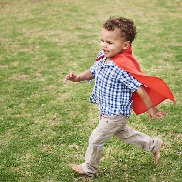 Confident Toddler Playing Super Hero In A Park